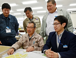 写真：町職員らと打ち合わせをする西尾さん