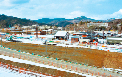 写真：JR女川駅（写真中央奥）前の、かさ上げされた市街地に店舗が次々と建設、にぎわいが戻り始める