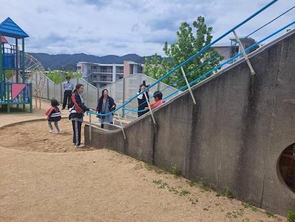 避難器具のすべり台で迅速に避難する園児の様子の写真