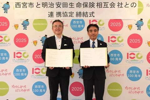 協定書を持つ明治安田生命保険相互会社阪神支社の田窪支社長と石井市長